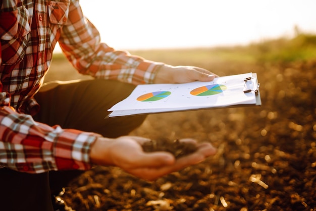 La mano de un agricultor experto recolecta suelo y verifica la salud del suelo antes de cultivar una semilla de verdura