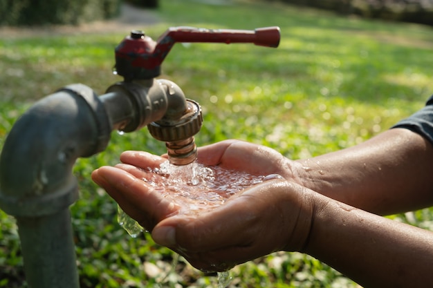 Foto mano de agua del grifo para beber.