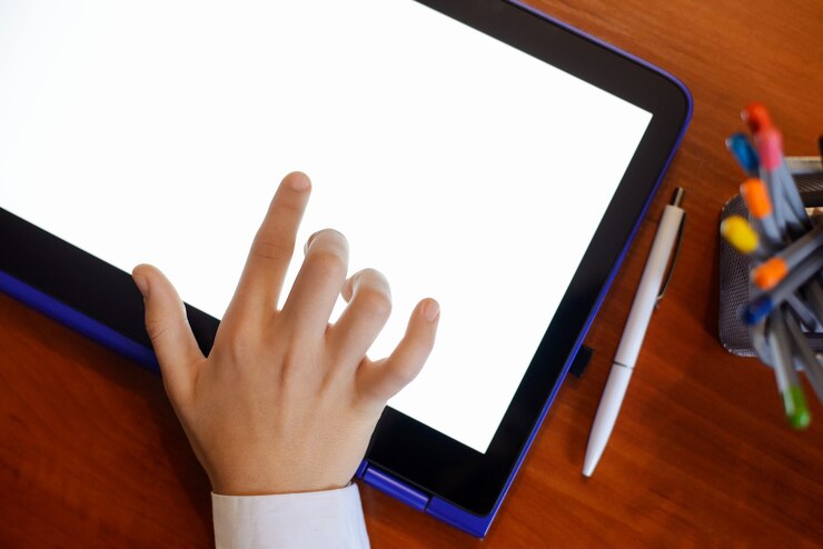 Foto mano de un alumno que trabaja con una tableta grande durante la cuarentena en casa
