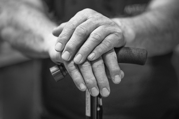 Foto mano de un anciano sosteniendo un bastón