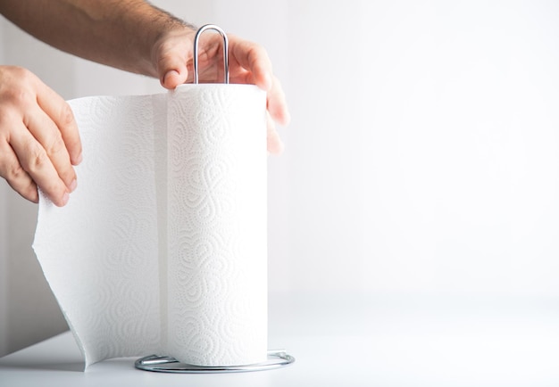 Una mano anónima está arrancando toallas de papel, el espacio de copia del concepto de higiene incluye
