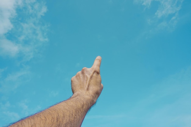 Foto mano arriba en el aire, gesticulando en el cielo sintiéndose libre