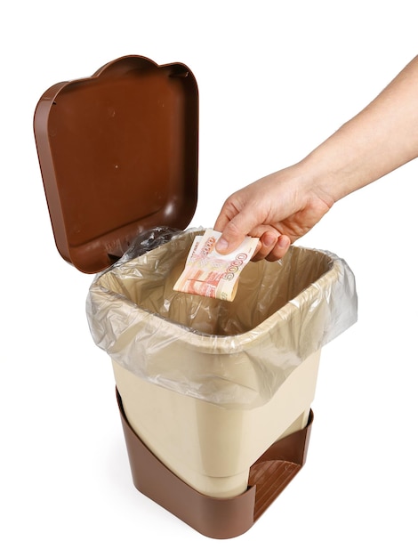 La mano arroja dinero billetes rusos en la caja de basura papelera concepto de inflación sobre fondo blanco.