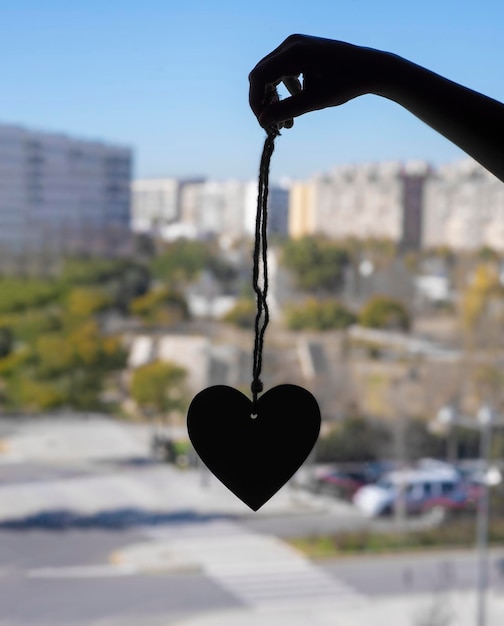 Mano atrapando el corazón en la luz de una ventana contra