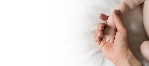 La mano de Baby39 en la palma de su padre sobre un fondo de pancarta blanca Cuidado de la protección de la paternidad