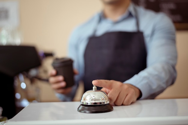 Mano de baristas tomando una taza de café caliente y panadería para ofrecer al cliente en la cafetería.