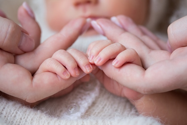 Foto la mano del bebé en las manos de la madre.