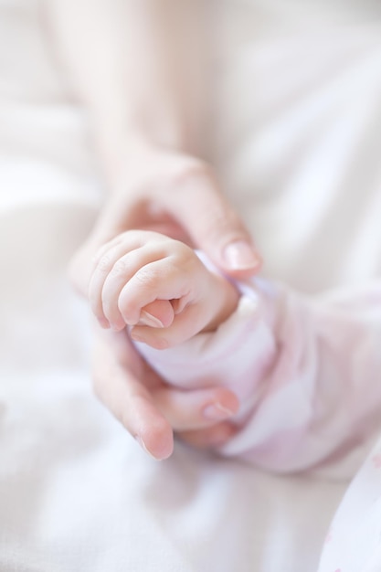 Mano de bebé recién nacido sosteniendo el dedo de la madre