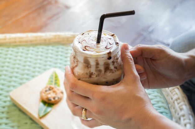 Mano en la bebida de chocolate helado