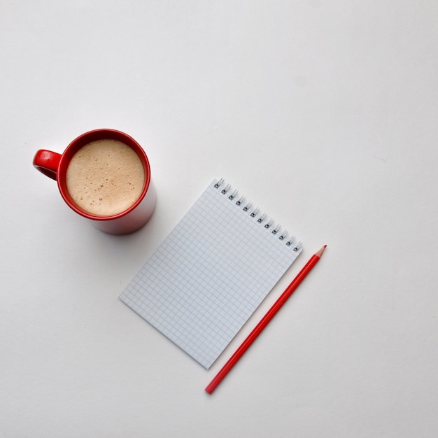 Una mano, un bloque, una taza de café en una silla. Haciendo un plan para el nuevo año