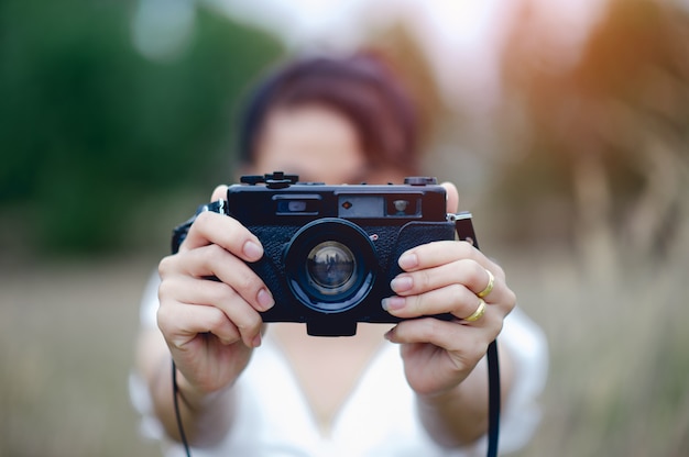 Mano y cámara del fotógrafo Sujetando y cargando la cámara para tomar fotografías.