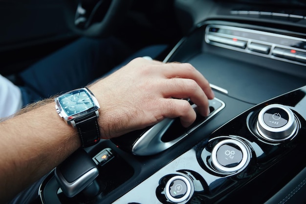 Mano en el cambio de marchas automático Mano de hombre cambiando un coche automático