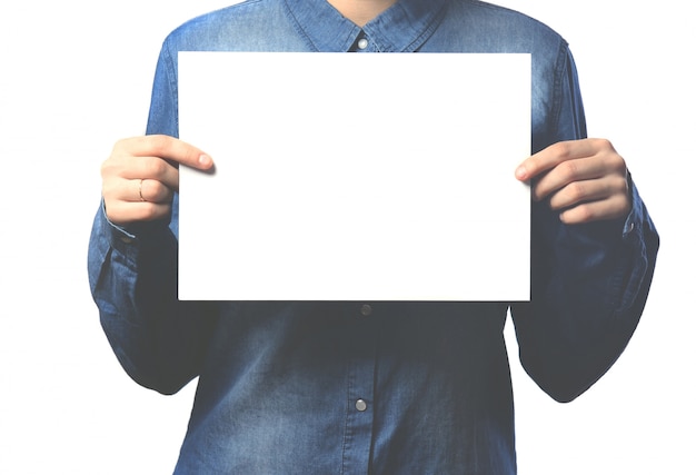 Foto la mano de la chica de la camisa vaquera con una hoja de papel.