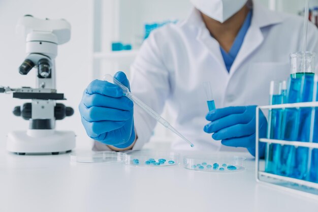 Mano de científico con tubo de ensayo y matraz en fondo de bandera azul de laboratorio de química médica