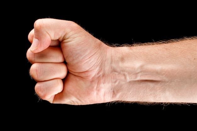 Foto la mano se cierra en un puño como símbolo de fuerza y resistencia.