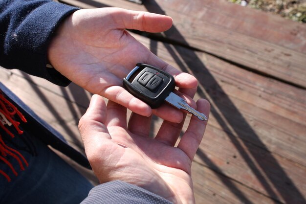 Mano del comprador tomando una llave de auto