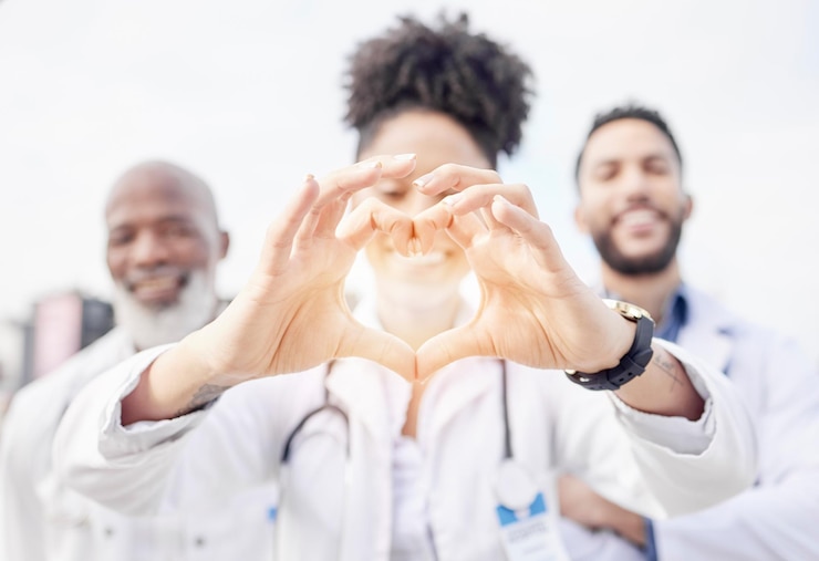 Foto mano de corazón feliz y retrato de médicos en la ciudad para atención y cuidado médico sonrisa medicina y trabajadores del hospital mostrando amor con manos emoji para enfermería profesional como equipo