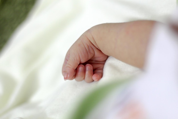 Foto la mano cortada del bebé en la cama