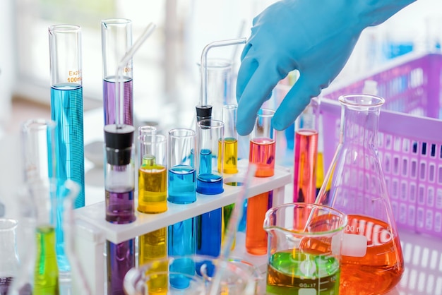 Mano cortada de un científico sosteniendo un tubo de ensayo en el laboratorio