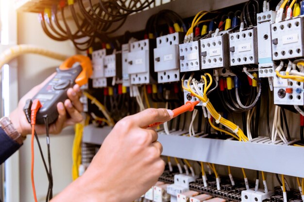 Foto mano cortada de un electricista reparando un fusible eléctrico en una fábrica