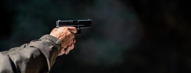 Foto mano cortada de un hombre con un arma