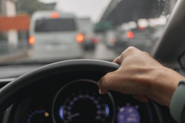 Mano cortada de un hombre conduciendo un coche