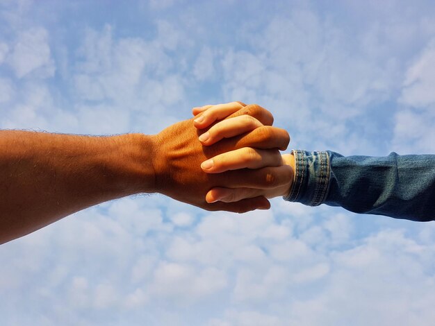 La mano cortada de un hombre contra el cielo