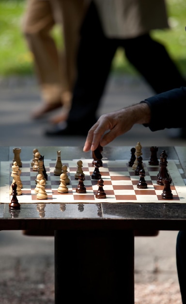 Mano cortada de un hombre jugando al ajedrez.