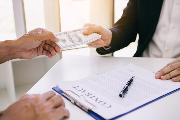 Foto la mano cortada de un hombre sobornando a un empresario en la mesa.