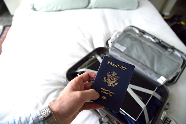 Mano cortada de un hombre sosteniendo el pasaporte en la habitación