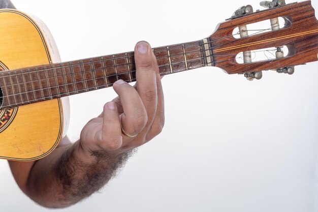 Foto mano cortada de un hombre tocando la guitarra contra un fondo blanco