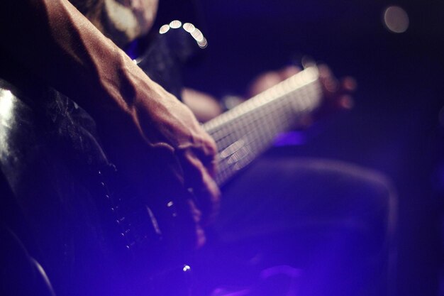Foto mano cortada de un hombre tocando la guitarra