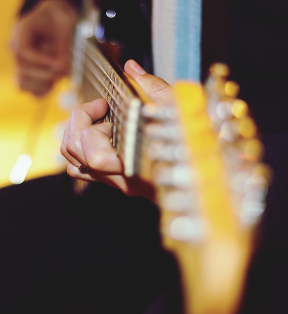 Foto mano cortada de un hombre tocando la guitarra