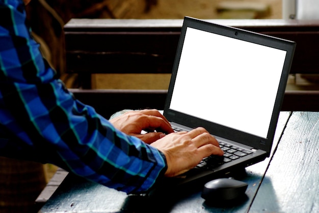 Mano cortada de un hombre usando una computadora portátil en la mesa