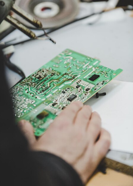 Mano cortada de un ingeniero reparando la placa base en la mesa