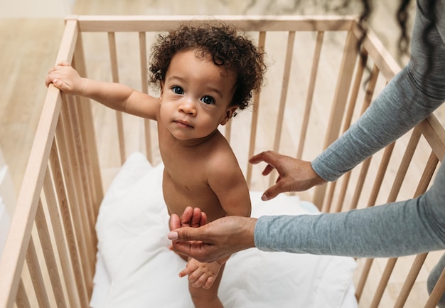 Foto la mano cortada de la madre por el hijo en la cuna en casa