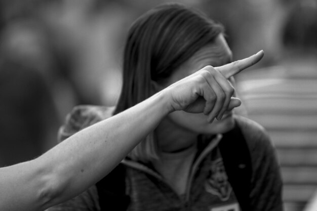 Foto la mano cortada de una mujer apuntando hacia afuera