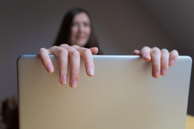 La mano cortada de una mujer cerrando la computadora portátil