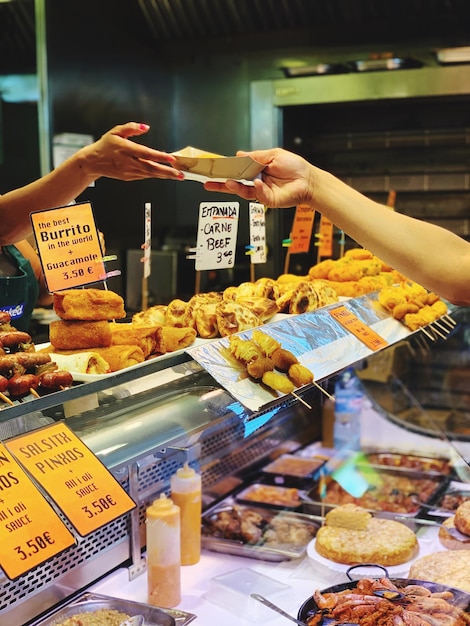 Foto mano cortada de una mujer comprando comida en una tienda