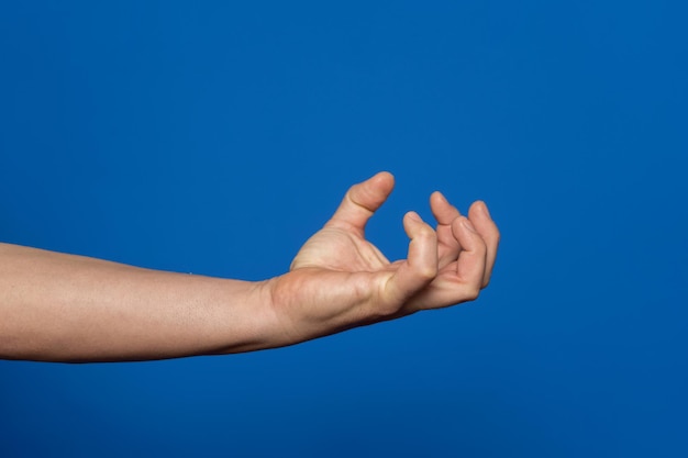 La mano cortada de una mujer contra el cielo azul claro