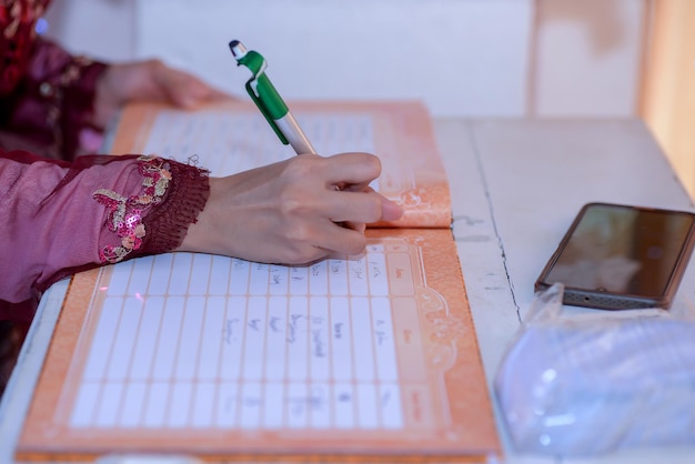 Foto mano cortada de una mujer escribiendo en un libro