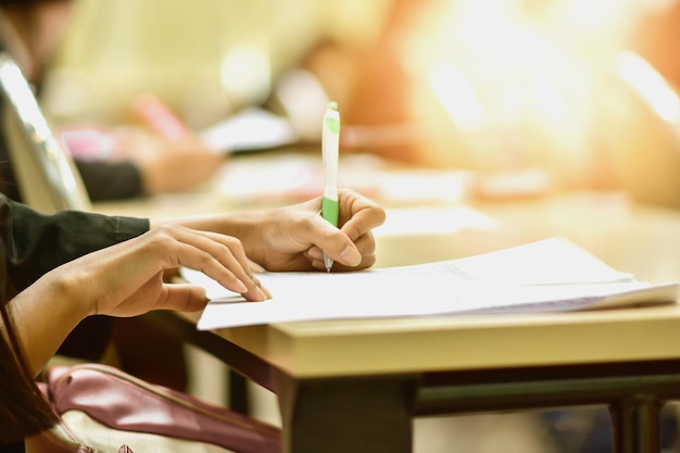 Mano cortada de una mujer escribiendo en papel en la mesa
