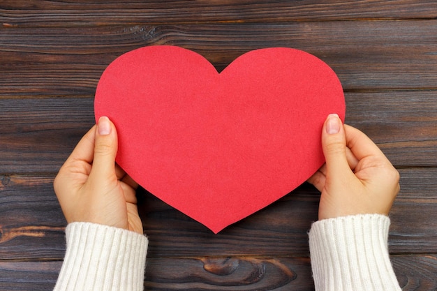 Foto mano cortada de una mujer con forma de corazón en la mesa