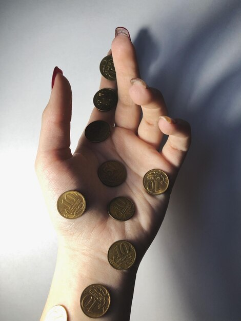 Foto mano cortada de una mujer con monedas en la mesa