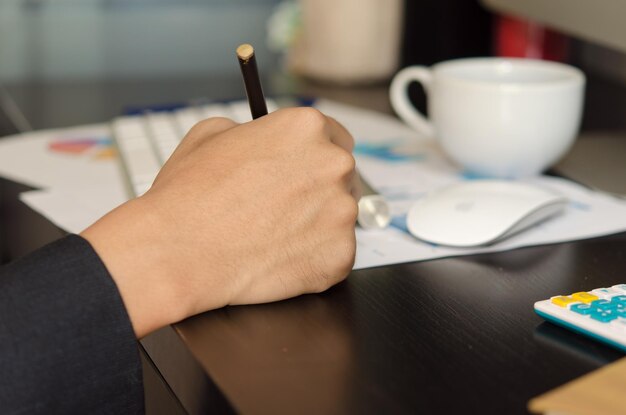 Foto la mano cortada de una mujer de negocios escribiendo en el escritorio