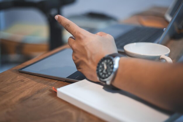 Foto la mano cortada de una mujer de negocios señalando en la oficina