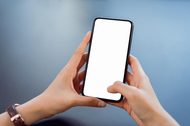 Mano cortada de una mujer de negocios usando un teléfono inteligente contra un fondo abstracto