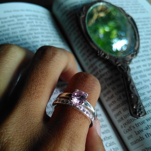 Mano cortada de una mujer que lleva un anillo en un libro
