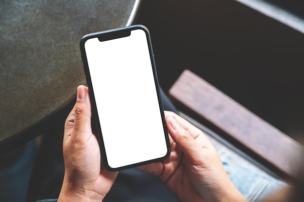 Mano cortada de una mujer que sostiene un teléfono móvil