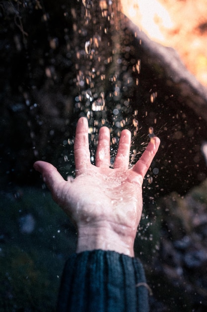 Foto la mano cortada de una mujer salpicando agua en un lago